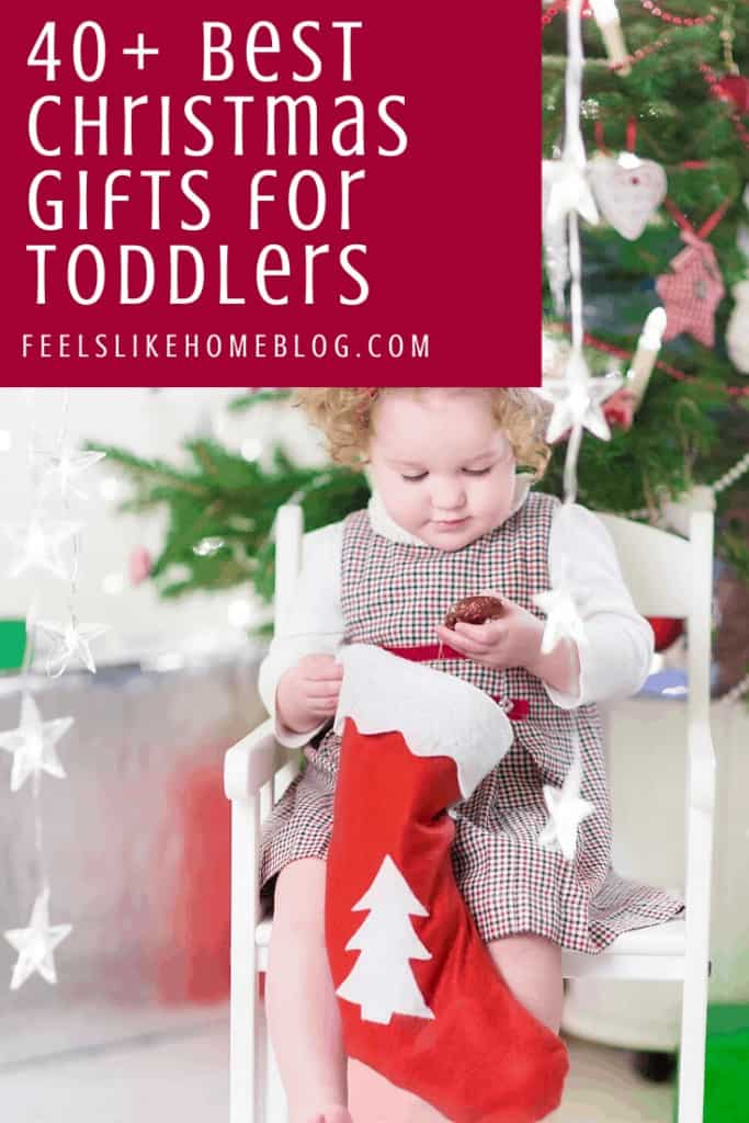 A toddler holding a Christmas stocking